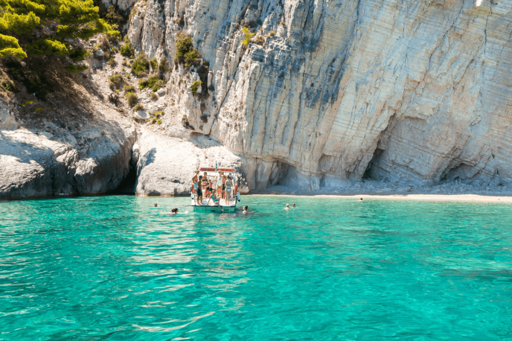 boat with people swimming in the see in a Greece cove
