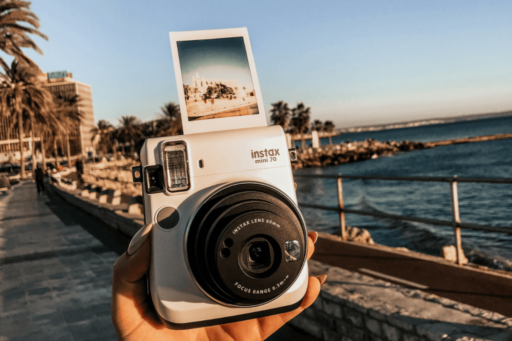 polaroid camera with picture in front of the sea
